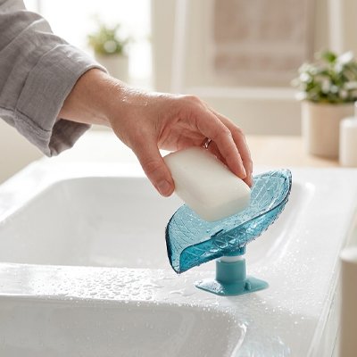 Porte savon ventouse transparent bleu avec savon au bord du lavabo