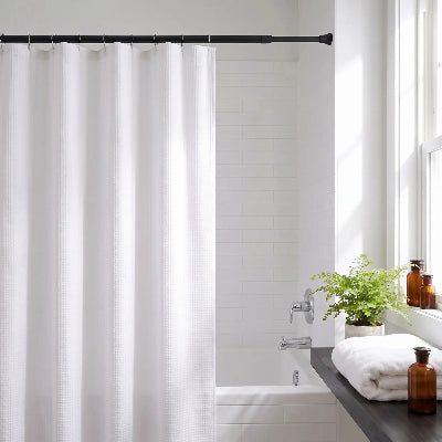 barre de rideau extensible noire avec des rideaux et des crochets camouflant une partie du bain