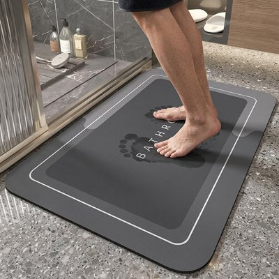 Tapis antidérapant salle de bain avec inscription bathroom dessus avec une personne les pieds mouillés