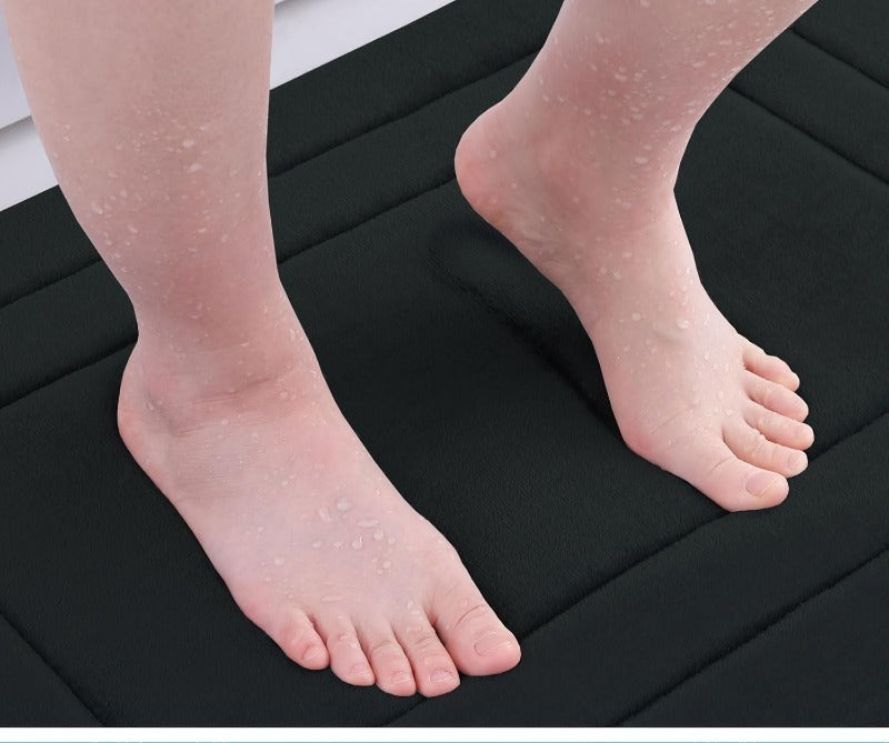 deux pieds sur tapis de salle bain noir