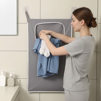 femme retire le linge du panier a linge salle de bain gris