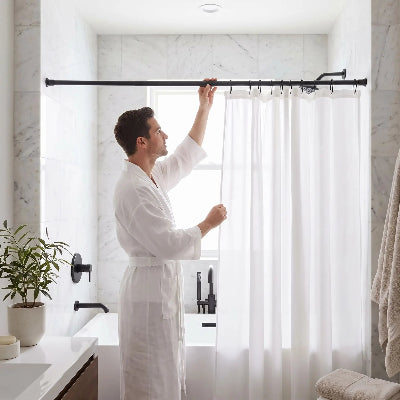 homme qui ajuste sa barre de douche de couleur noire