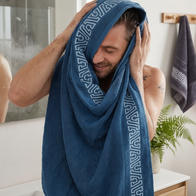 homme qui sessuie la tête avec le drap bleu et une serviette sur le crochet