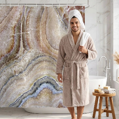 homme sortant de la douche devant son rideaux douche au motif onyx aux couleurs beige brun terre