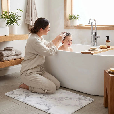 jeune maman à genoux sur le tapis absorbant pour salle de bain qui les cheveux de son enfant