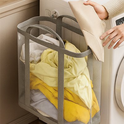 panier a linge pour salle de bain gris remplis de vêtements 
