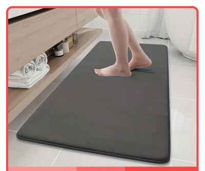 personne devant le comptoir avec les  pieds sur le tapis de bain diatomite gris