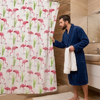 rideau douche avec flamands roses et homme en peignoir marine qui tient une serviette blanche
