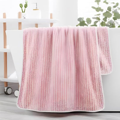 serviette de bain lot en rose sur le rebord du bain