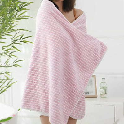 serviette de bain lot en rose sur les épaules de femme
