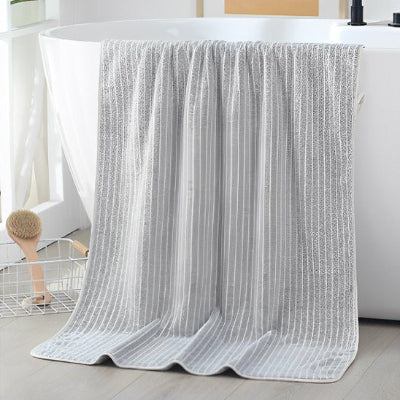 serviette de bain lot gris sur le rebord du bain
