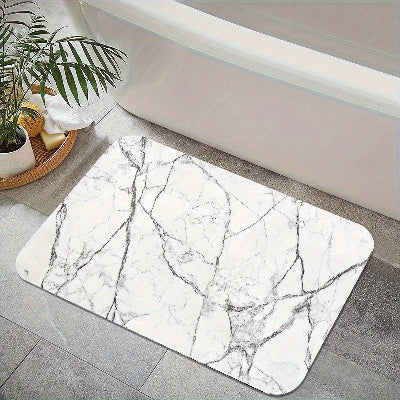 tapis absorbant pour salle de bain aux motifs de marbre près du bain
