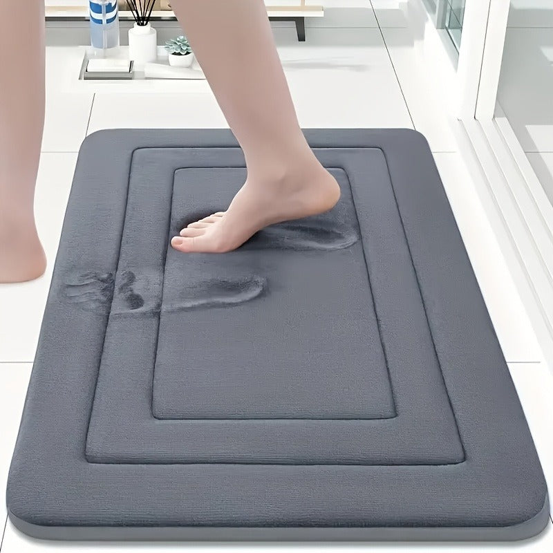 un pied sur tapis de salle de bain gris fonce