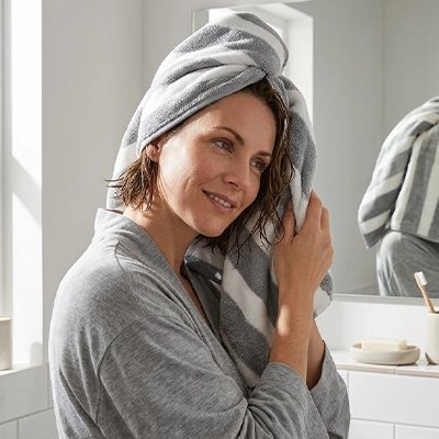 une serviette grise du lot de serviette de bain sur la tête dune femme